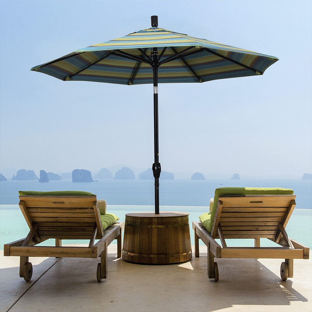 Image of the Pacific Trail Series Residential Patio Umbrella by California Umbrella, set against an expansive backyard that echoes the enduring beauty of the Pacific Crest Trail. This umbrella features durable aluminum construction and market-style design, offering reliable and stylish shade suitable for larger outdoor retreats. Equipped with a smooth crank lift and push-button tilt, the Pacific Trail Series allows for easy adjustment of shade, ensuring optimal comfort throughout the day. The sturdy aluminum ribs enhance its durability, making it a perfect blend of elegance and functionality for residential outdoor spaces.