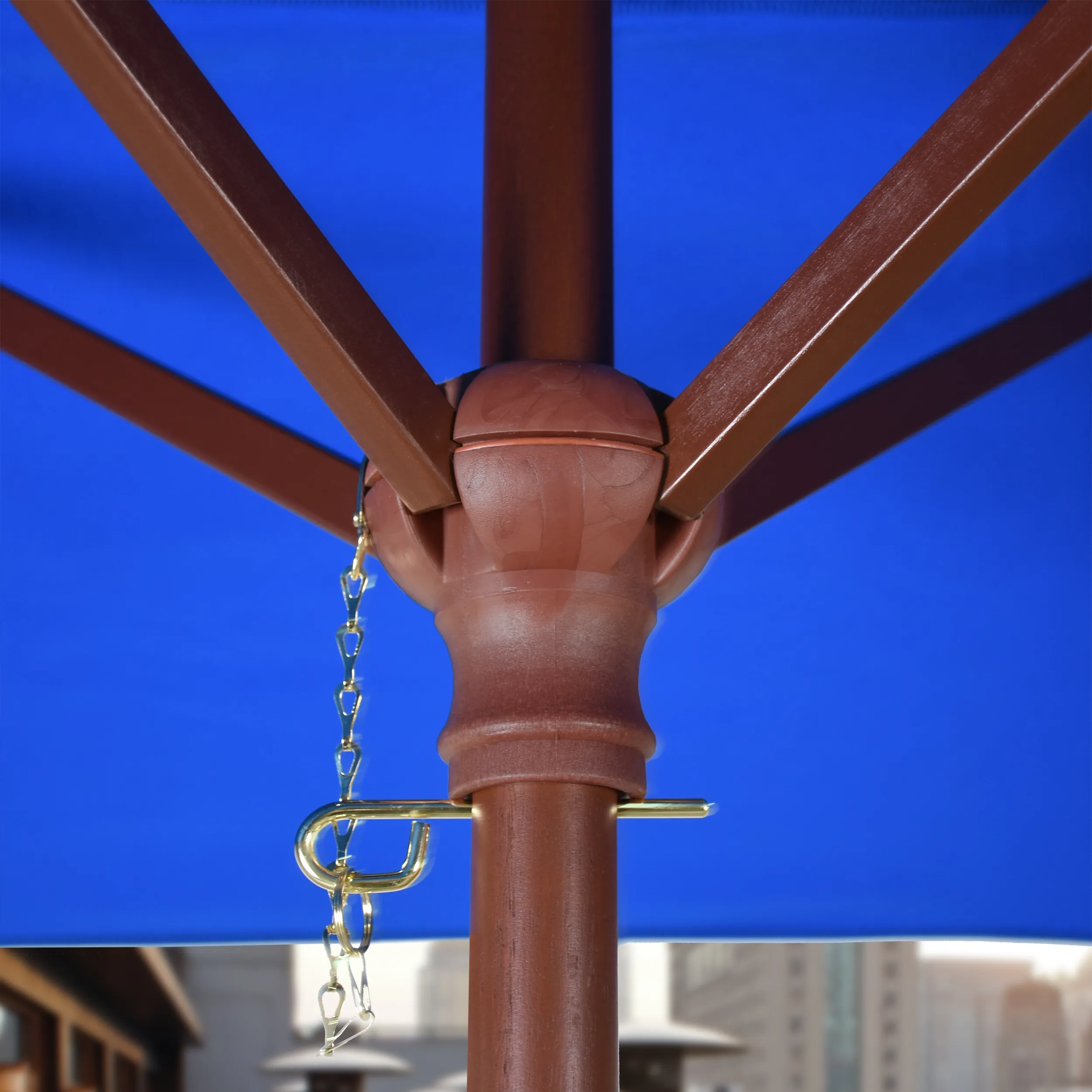 Close-up of the push lift system on the Grove Series commercial patio umbrella by California Umbrella, highlighting its durable all-wood frame and easy-to-use functionality for upscale outdoor settings.