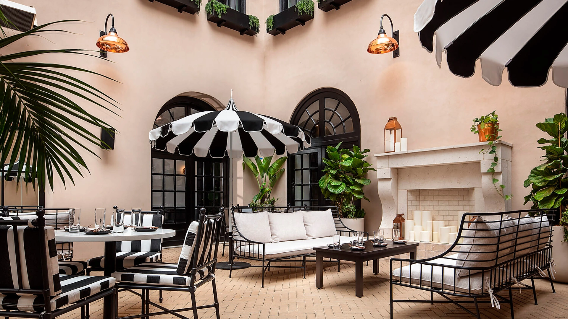 A Pagoda Series Patio Umbrella with an elegant alternating panel pagoda-cut canopy and vibrant Sunbrella fabric stands in a serene courtyard. Designed for both commercial and residential use, this unique umbrella combines timeless style with durable, weather-resistant shade.